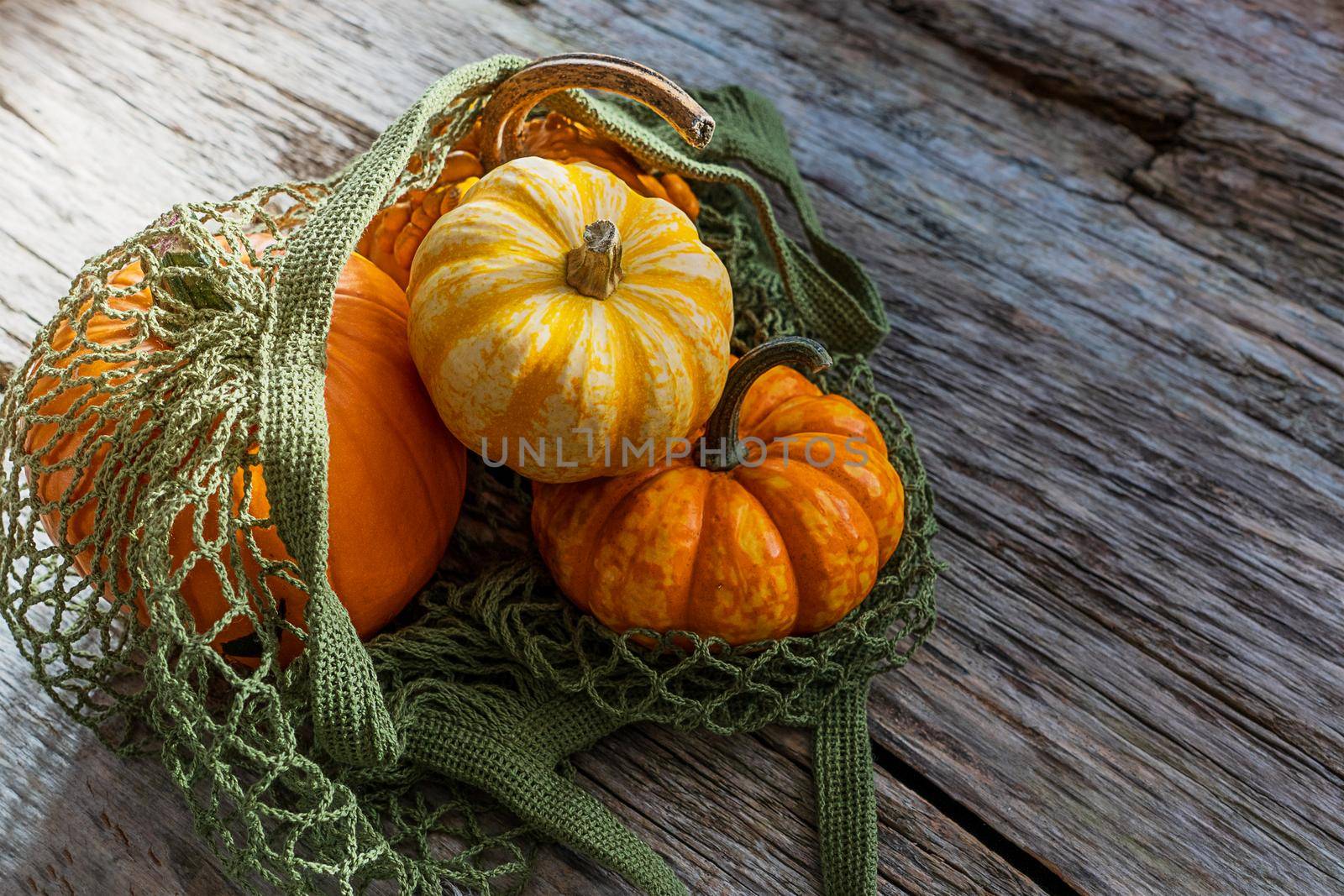 Still life, top view, flat lay. Autumn vegetables, pumpkin, in a bag. Alternative packaging instead of plastic bag, rope bag. Banner with wooden old background with copy space. farm food, close-up