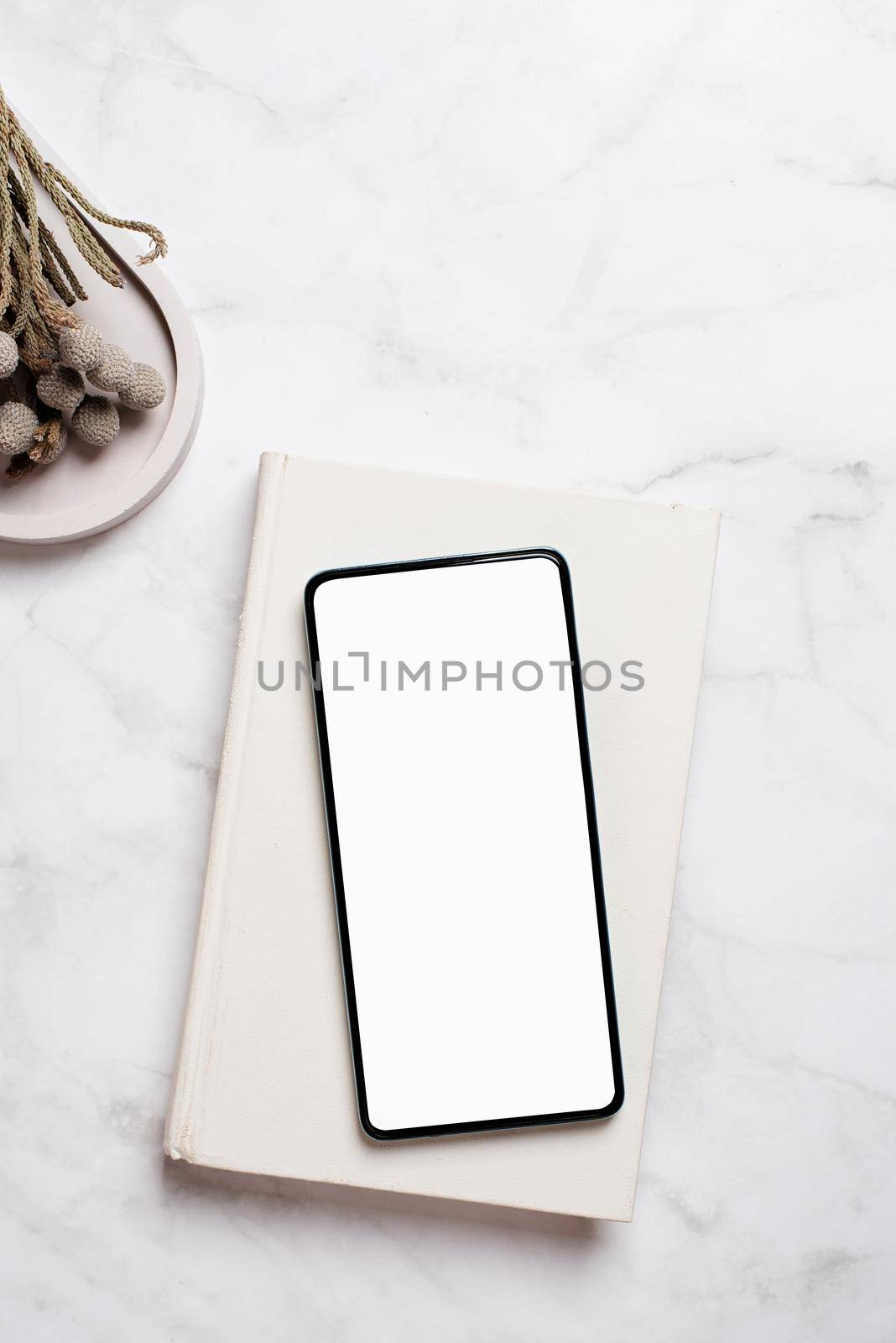 smartphone with isolated screen on marble table for mockup design. At home interior.
