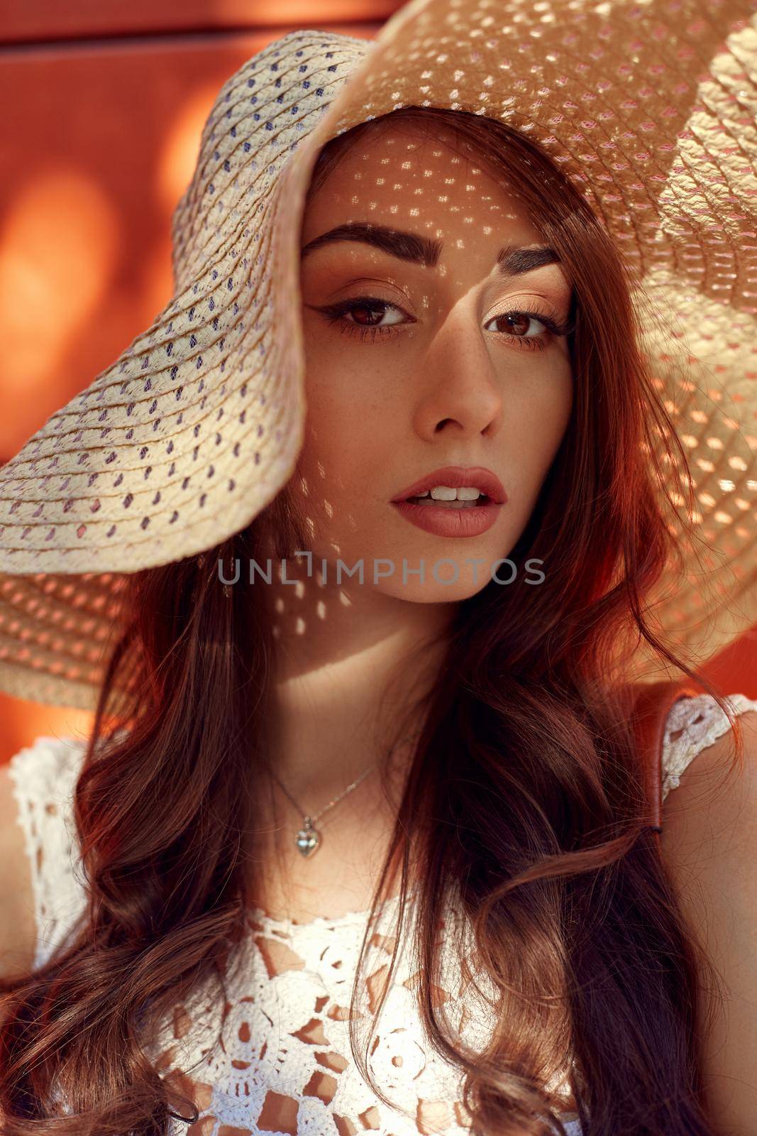 Sunny lifestyle fashion portrait of young stylish hipster woman walking on the street, wearing trendy outfit, straw hat, travel.