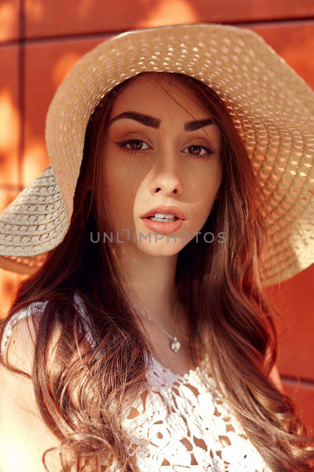 Sunny lifestyle fashion portrait of young stylish hipster woman walking on the street, wearing trendy outfit, straw hat, travel.