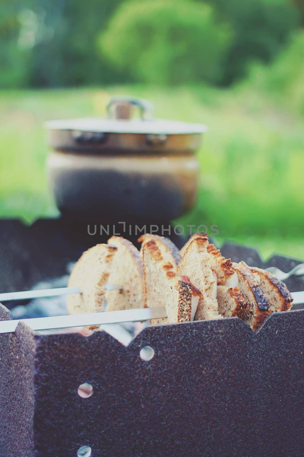 Grilling meat and bread on skewer over the brazier.