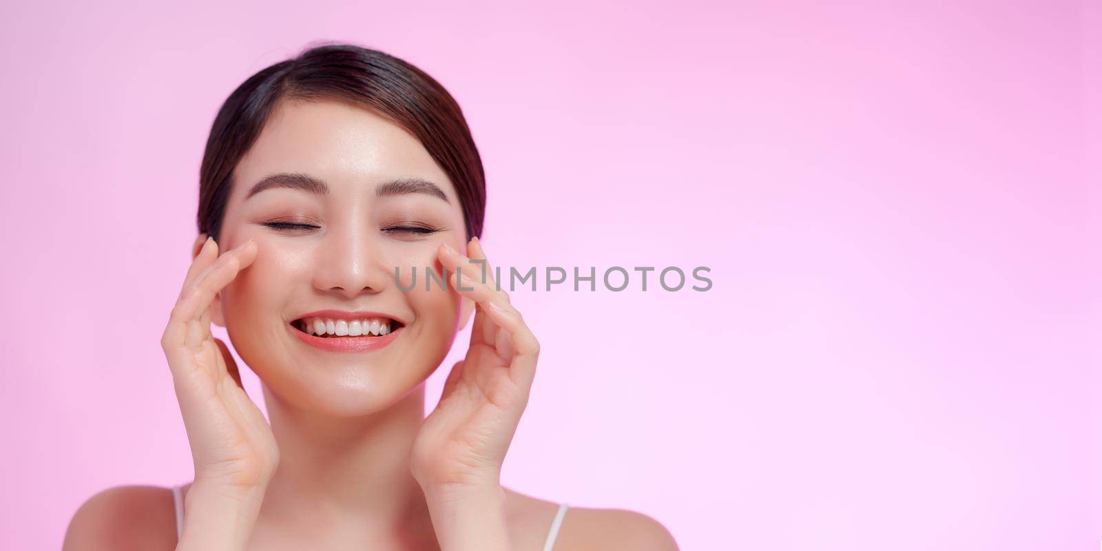 Beautiful elegant woman with bare shoulders clean skin spa treatments isolated on pink background by makidotvn