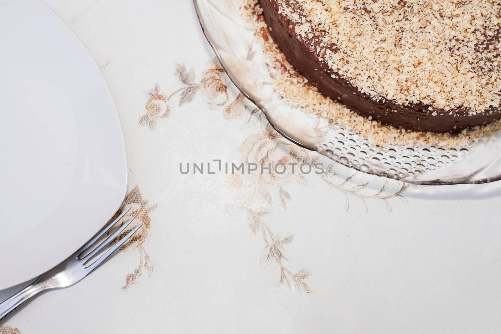 Part of a brown cake sprinkled with light brown chocolate. You can see the fork. Flat lays.