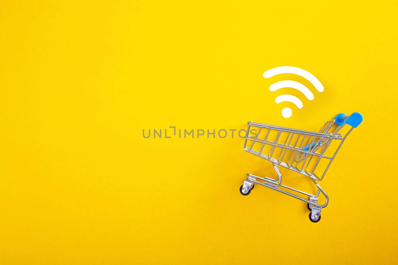 close-up of shopping trolley with wifi signal on yellow background by tehcheesiong