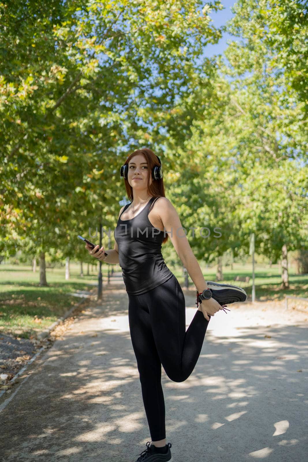 Portrait of fit and sporty young woman doing stretching in public park. stock photography