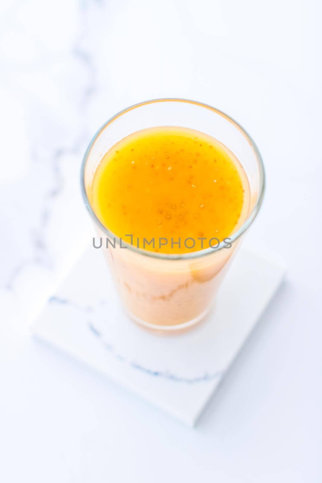 Glass of orange fruit smoothie juice with chia seeds for diet detox, perfect breakfast recipe by Anneleven