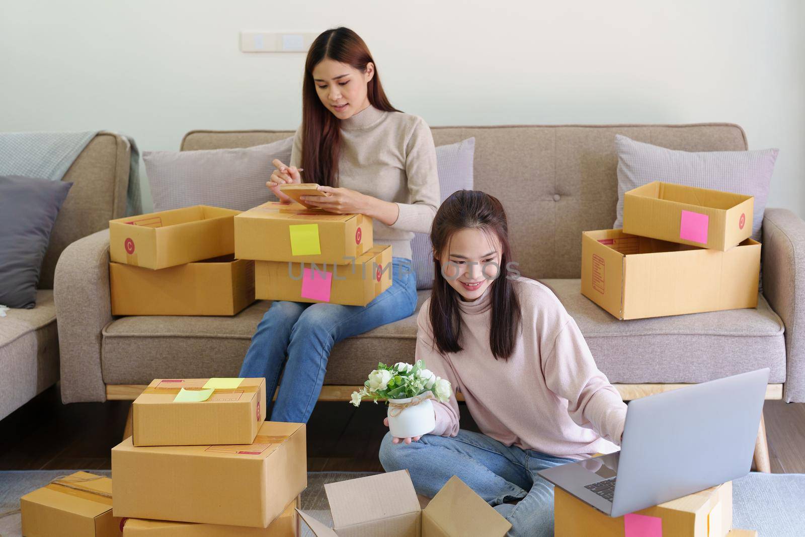 Portrait of Starting small businesses, two Asian woman check online orders Selling products working with boxs freelance work at home office, sme business concepts