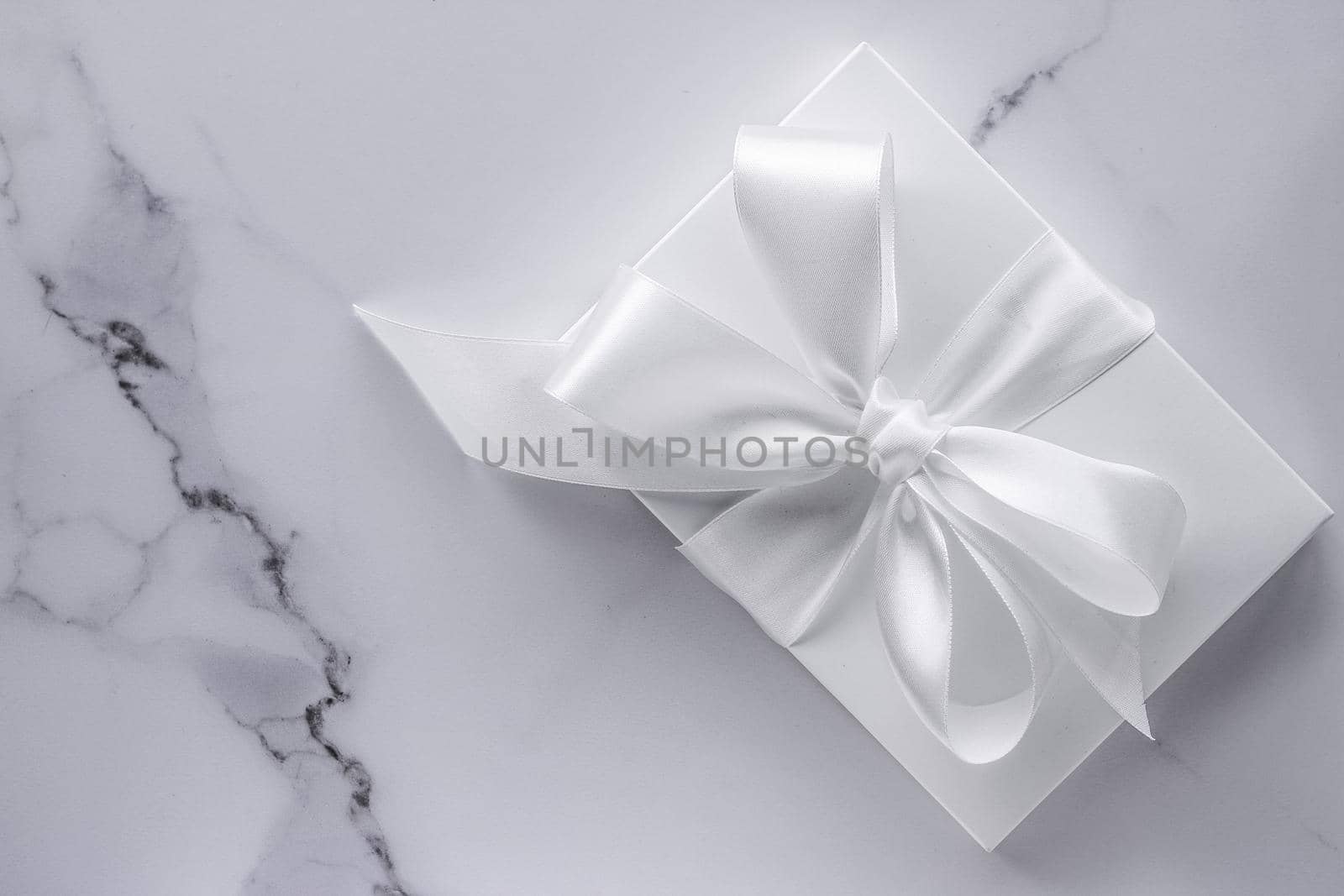 Romantic celebration, bridal decor and holiday present concept - Luxury wedding gifts with silk bow and ribbons on marble background