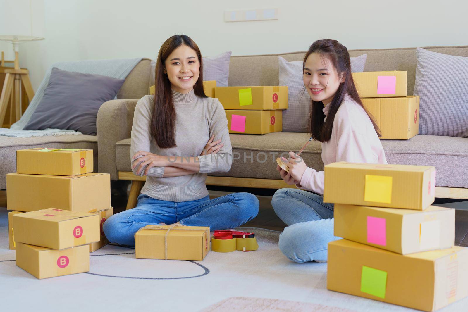 A businesswoman sells items online and checks the goods for packing by Manastrong