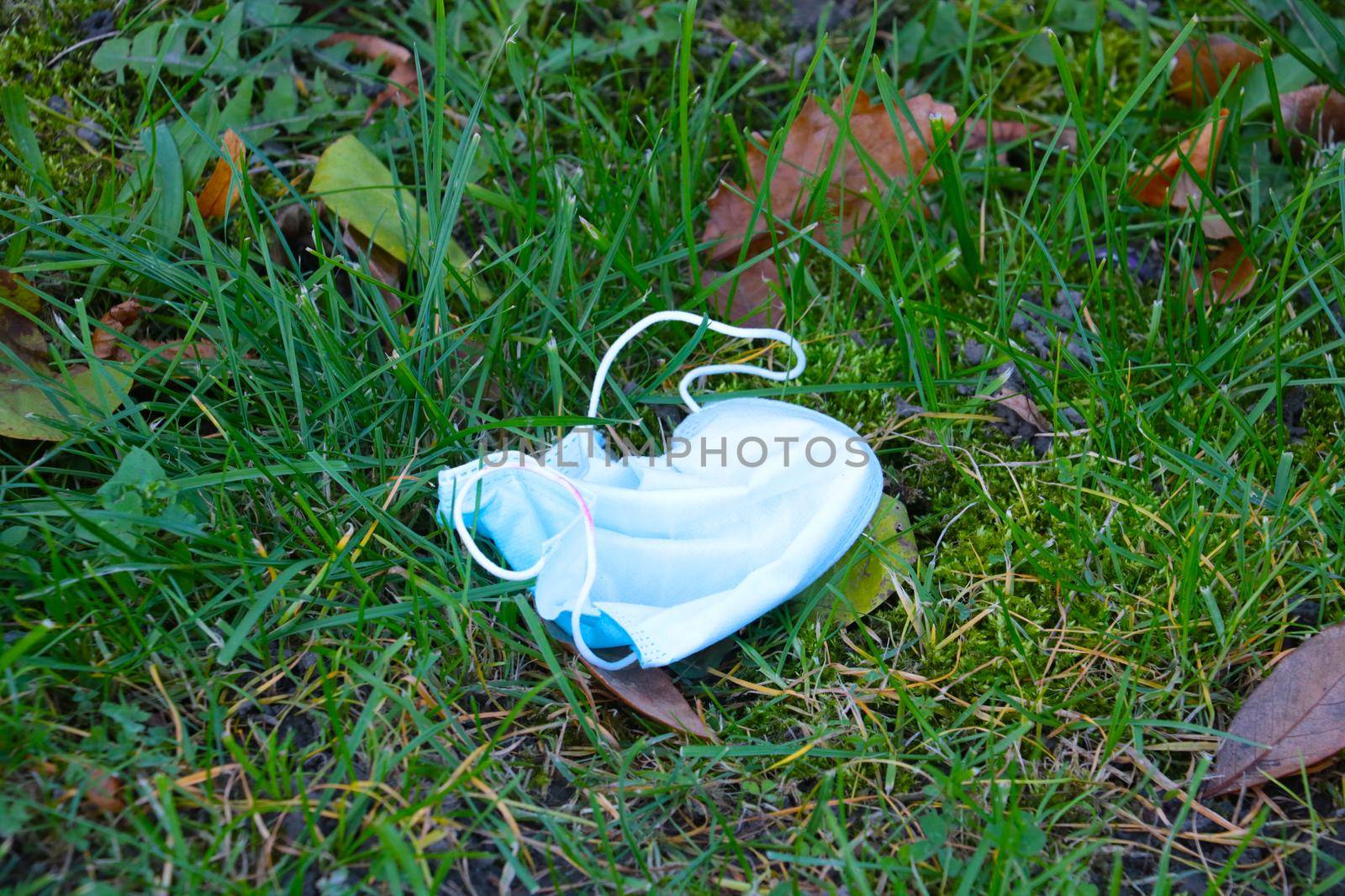 A used medical mask is on the ground