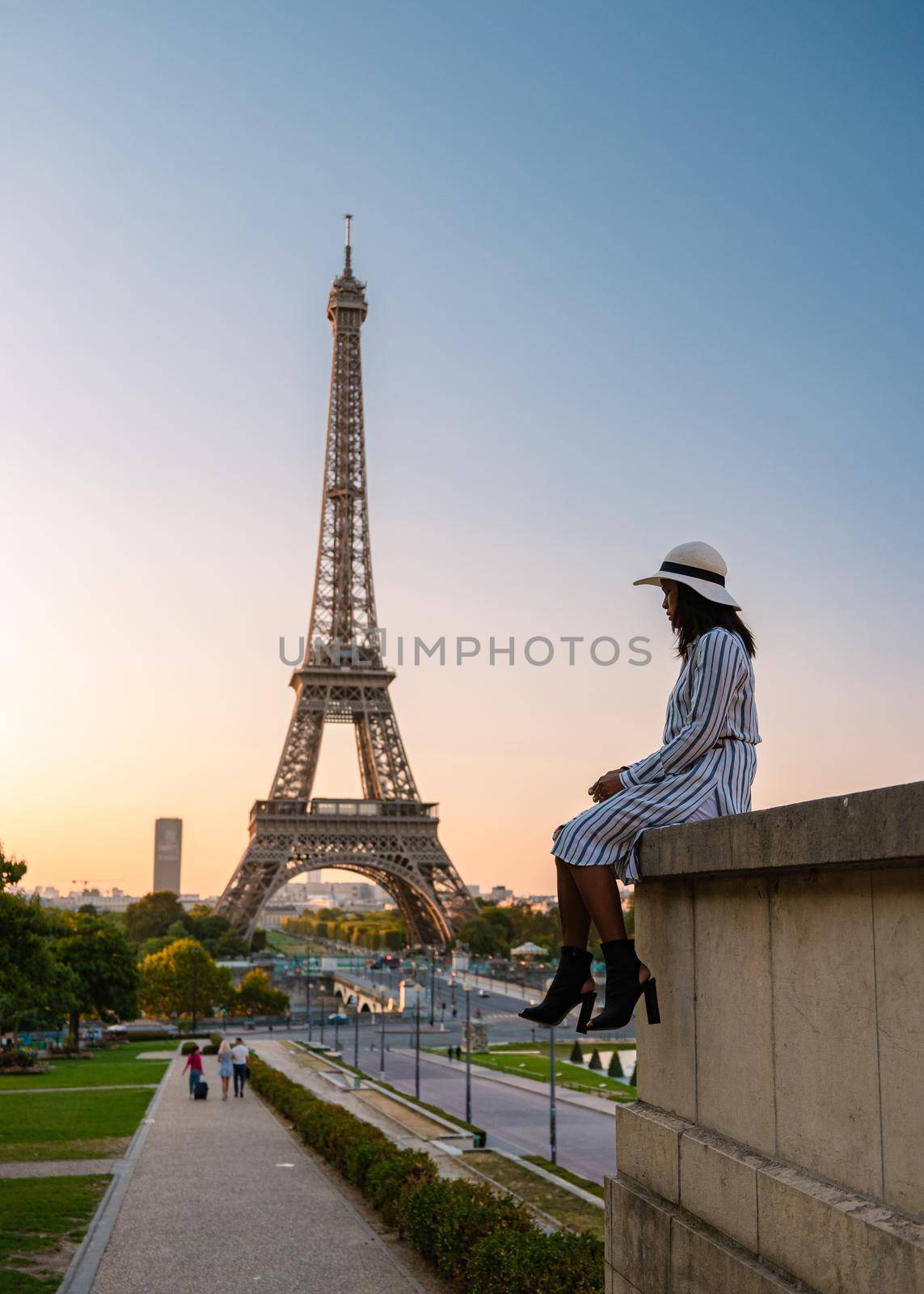 Young women with a hat visiting Eiffel tower at Sunrise in Paris France, Paris Eifel tower on a summer day in the city of Paris France