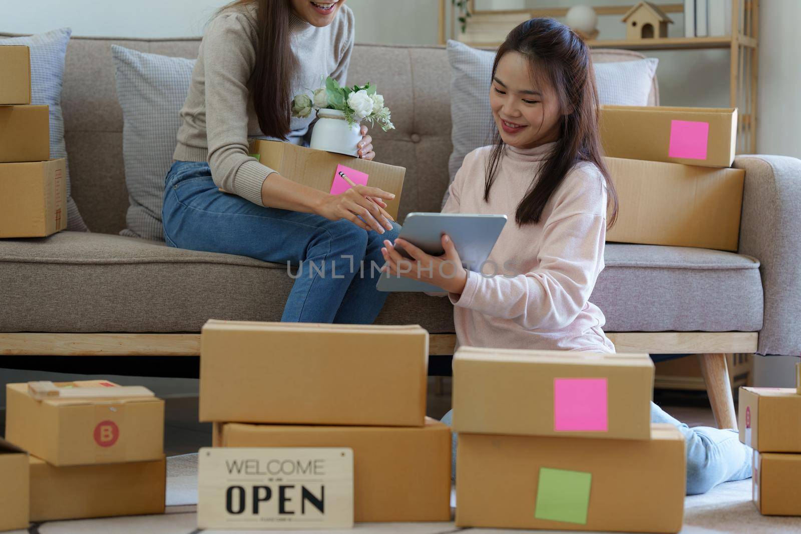 Asian SME business woman with partner working at home office. online shopping concept.