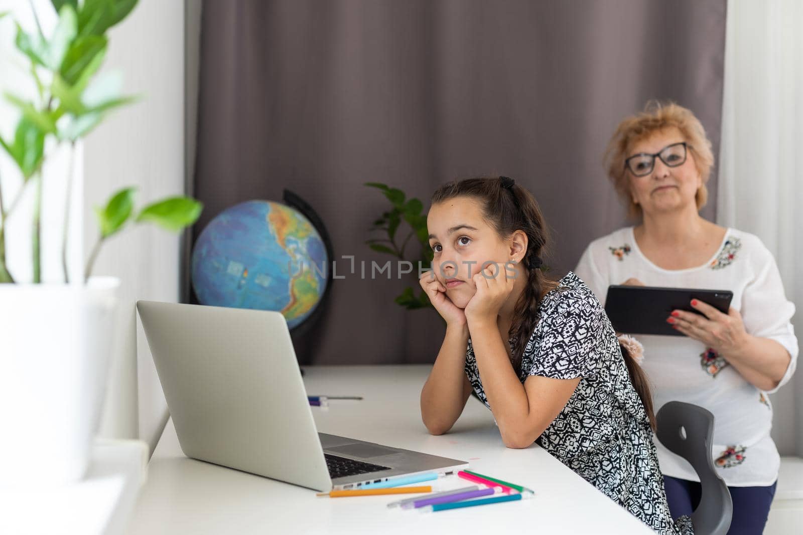 Grandmother and granddaughter using tablet and laptop