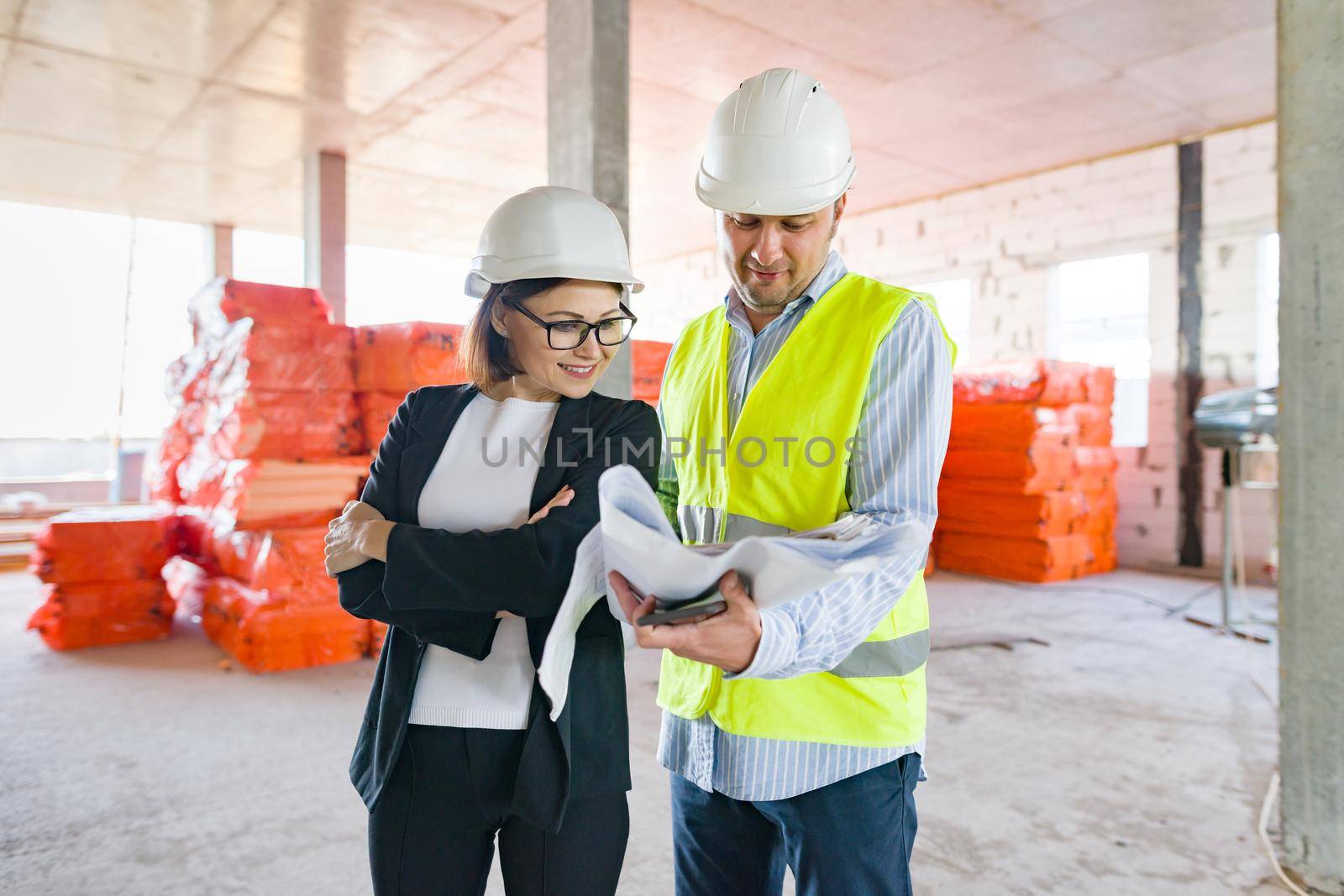 Industrial portrait of male and female engineers in construction of commercial administrative building