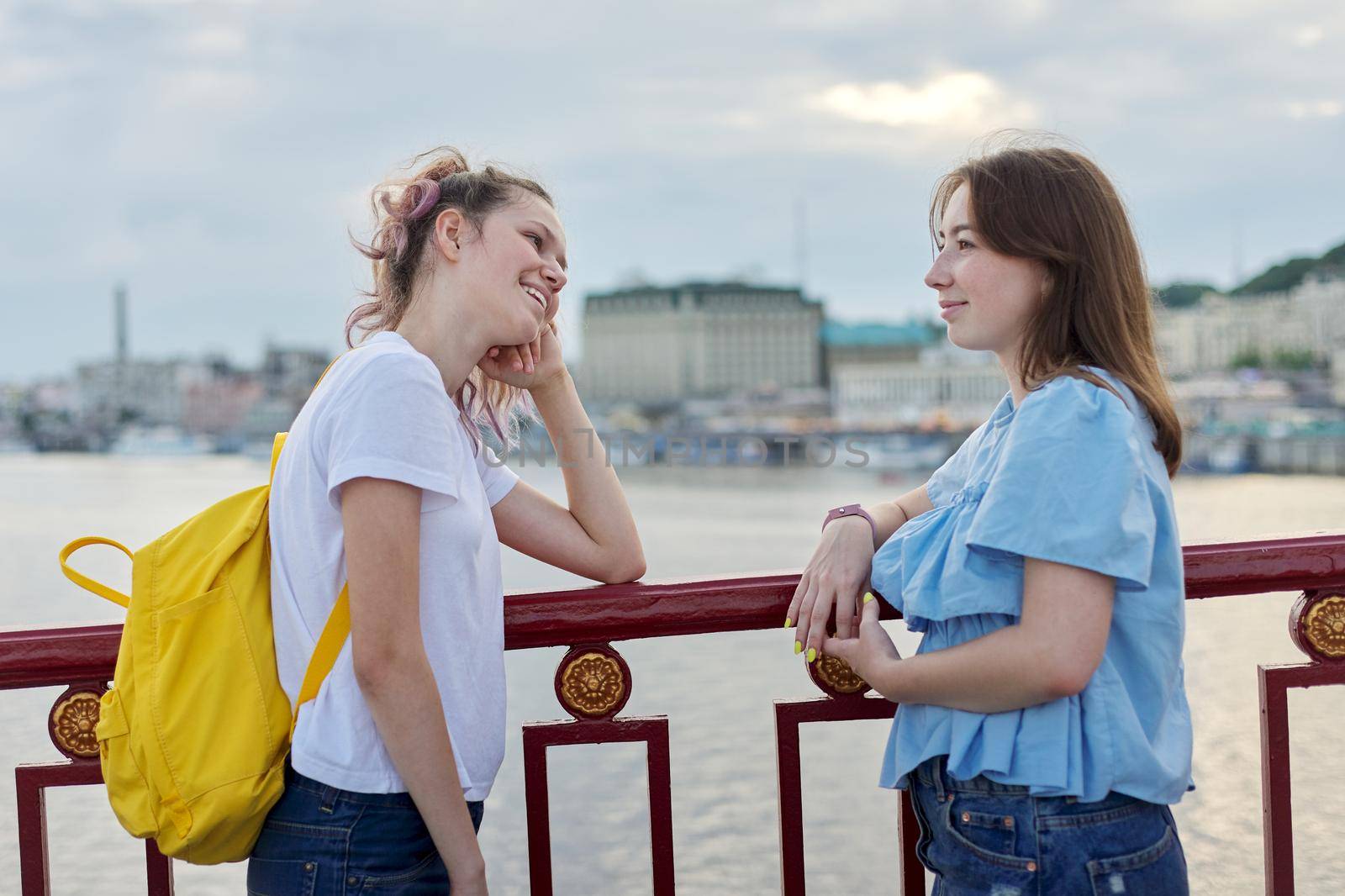 Portrait of two teenage girls friends walking and talking on sunny summer day by VH-studio