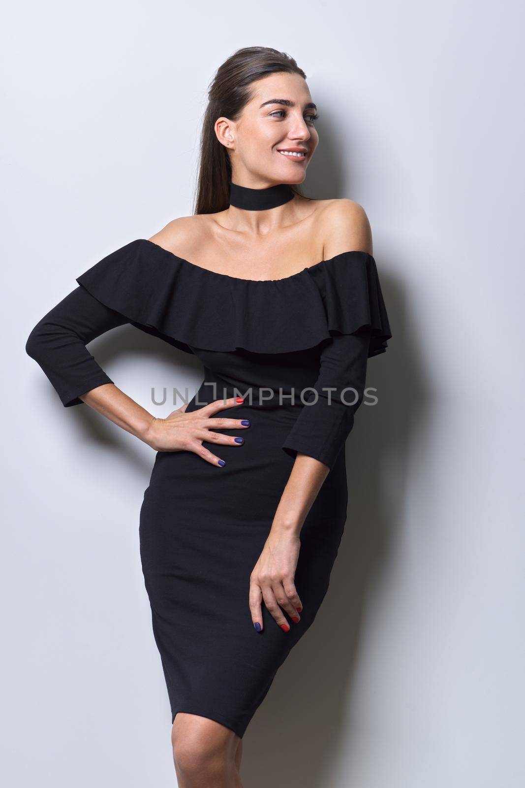 Beauty fashion portrait of young beautiful woman in small black dress with bare shoulders, long straight healthy hair with choker accessory on neck on white background
