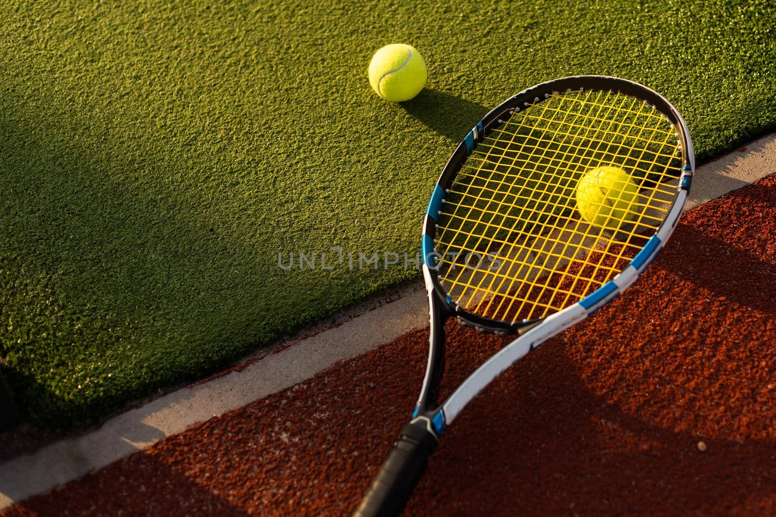 tennis balls and racket on the green grass background.