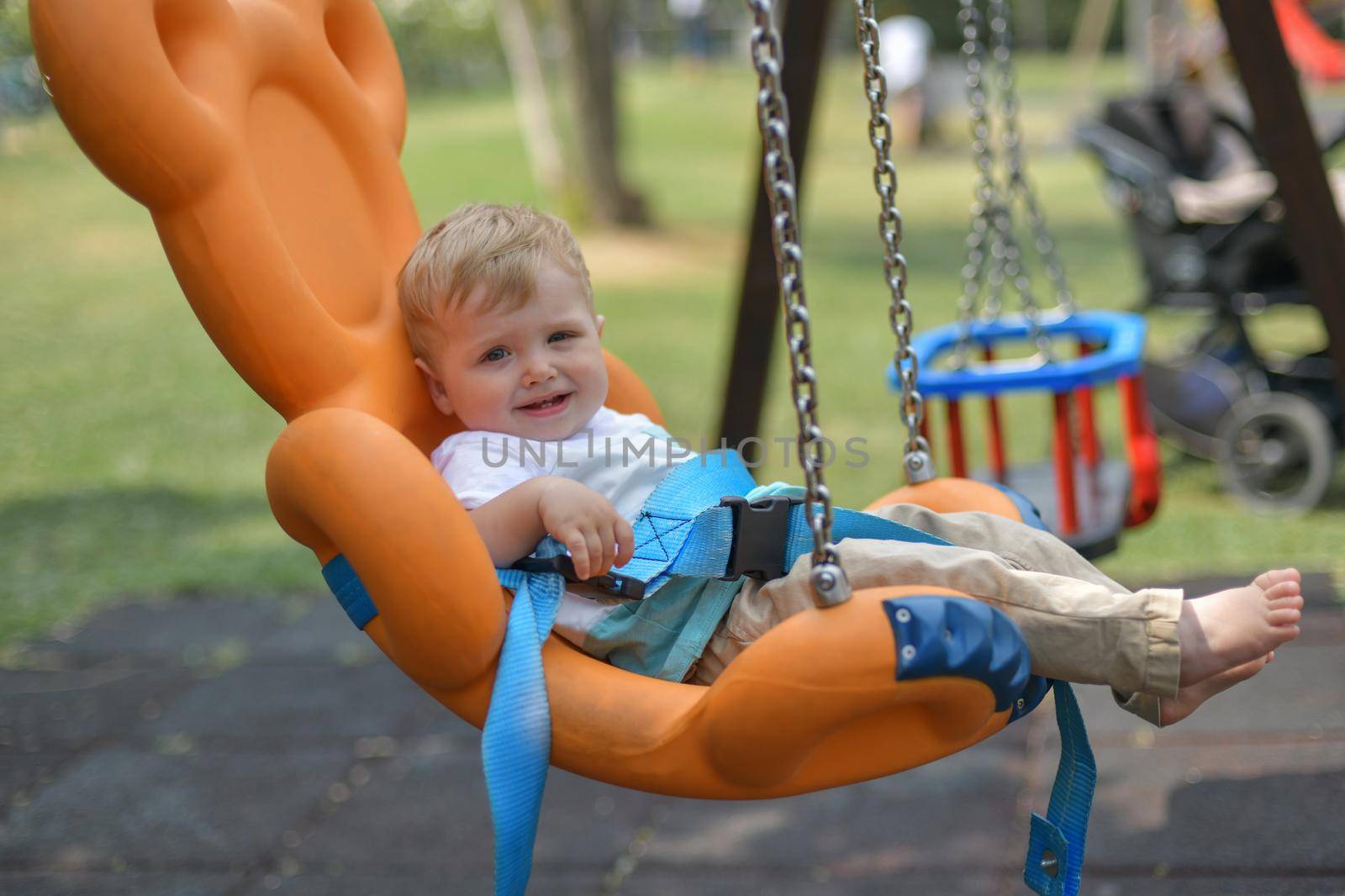 Smiling baby boy sitting in a swing