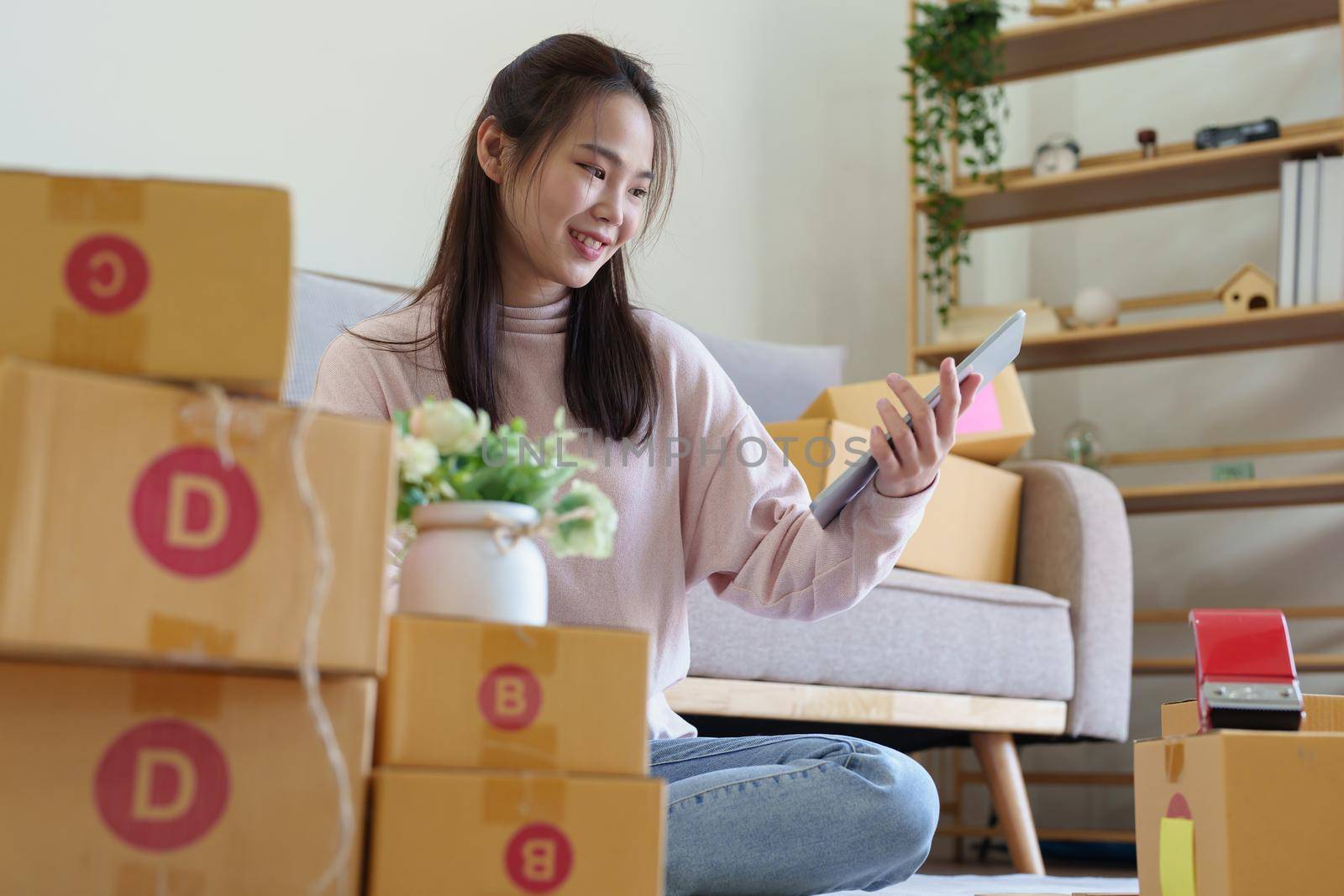 Portrait of Starting small businesses, Asian woman check online orders Selling products working with boxs freelance work at home office, sme business concepts