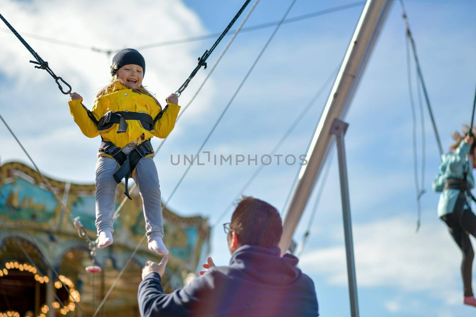 A smilling girl jumping on a trampoline with insurance.