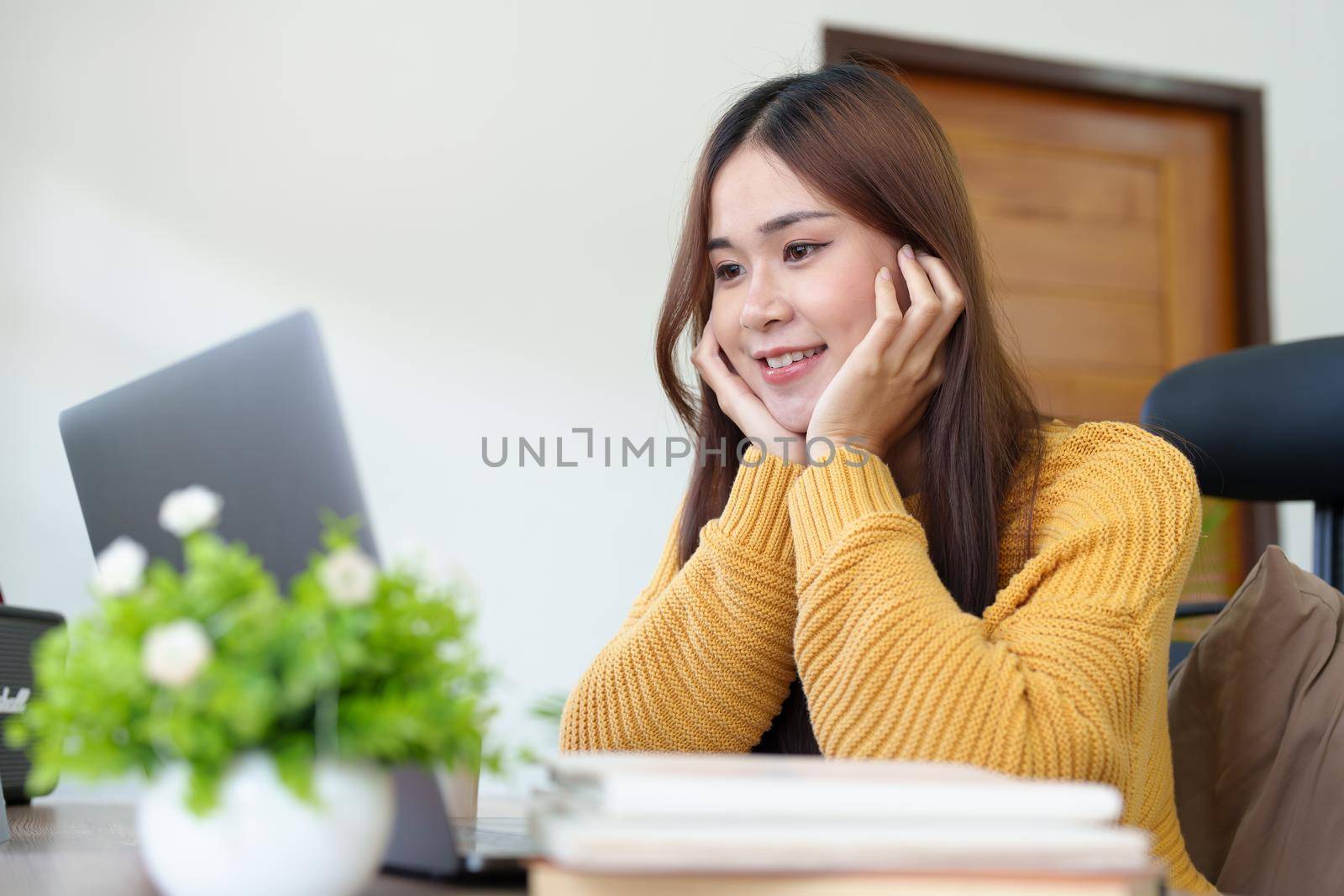 woman smiling happily while using computer at home.