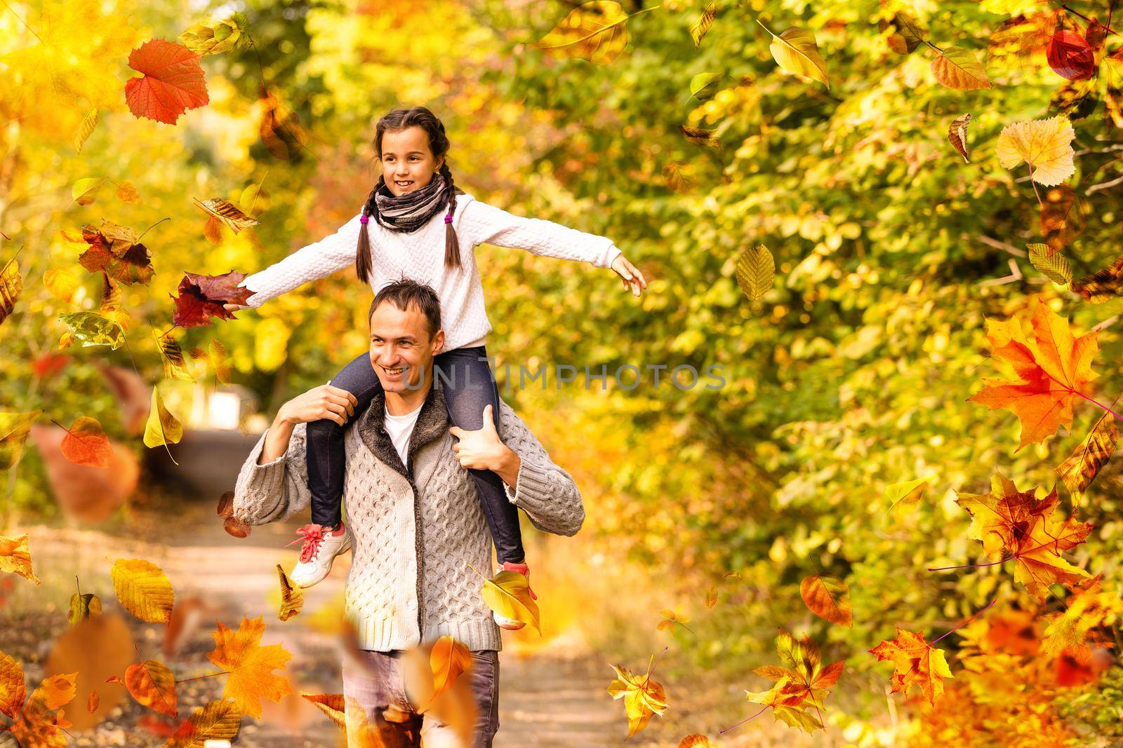 happy family father and child girl daughter playing and laughing in autumn park . High quality photo