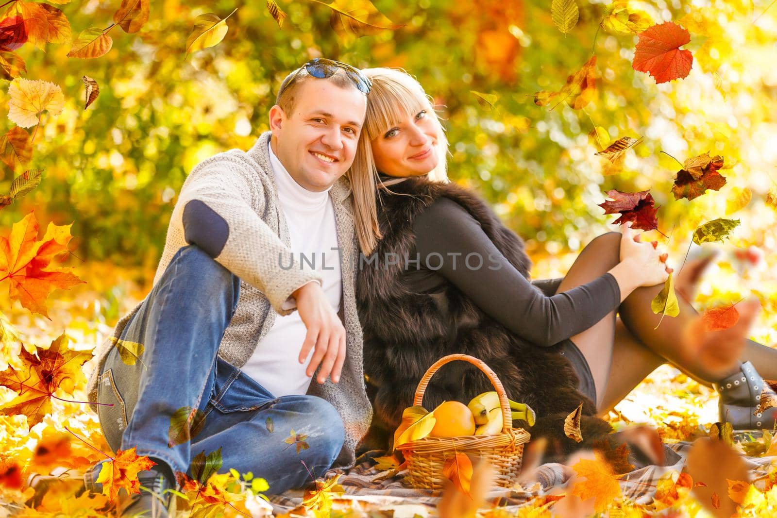 Young couple in love holding hands and walking through a park on a sunny autumn day by Andelov13