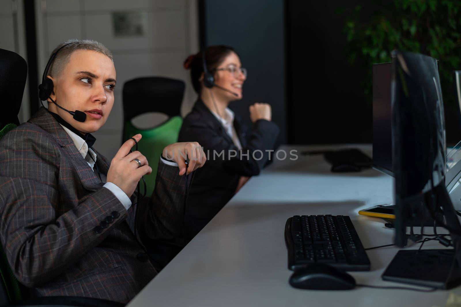 Two women in protective masks are bored at work. Call center operators at the desk by mrwed54