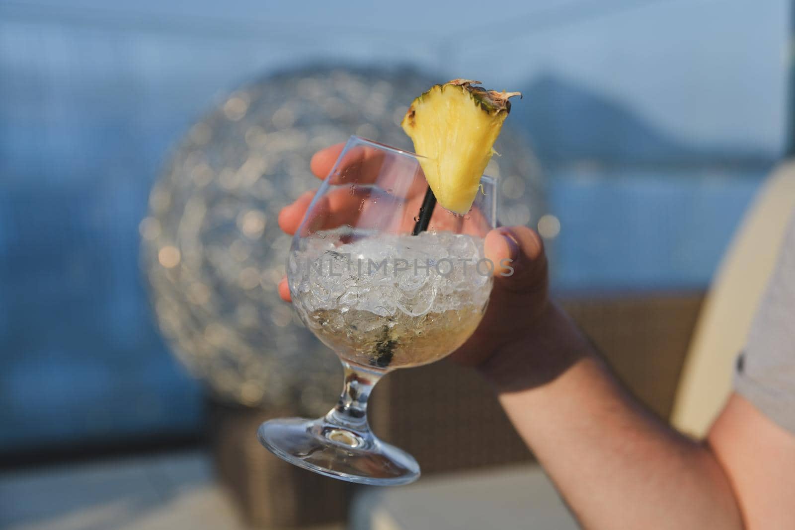 Hand holding a pina colada cocktail with ice