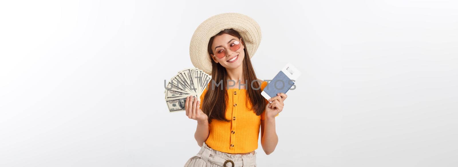 Portrait of cheerful, happy, laughing girl with hat on head, having money fan and passport with tickets in hands, isolated on white background by Benzoix