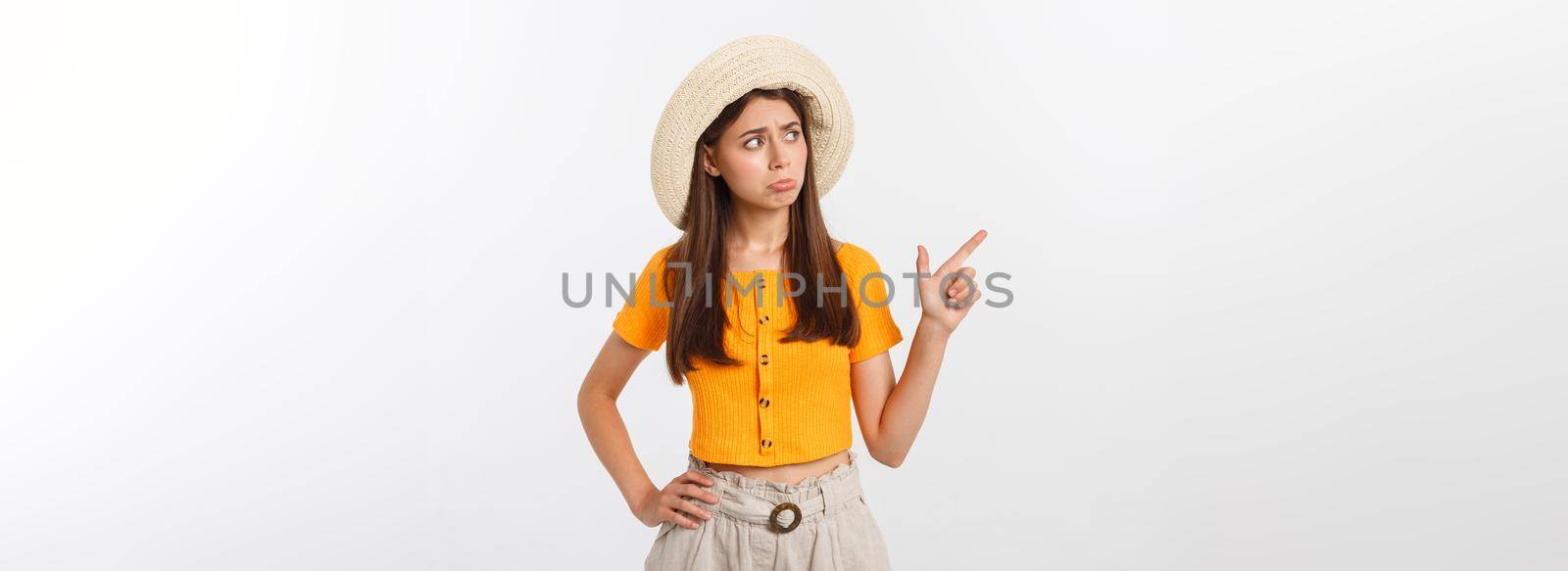 young pretty woman looking unhappy and stressed, suicide gesture making gun sign with hand, pointing to copy space