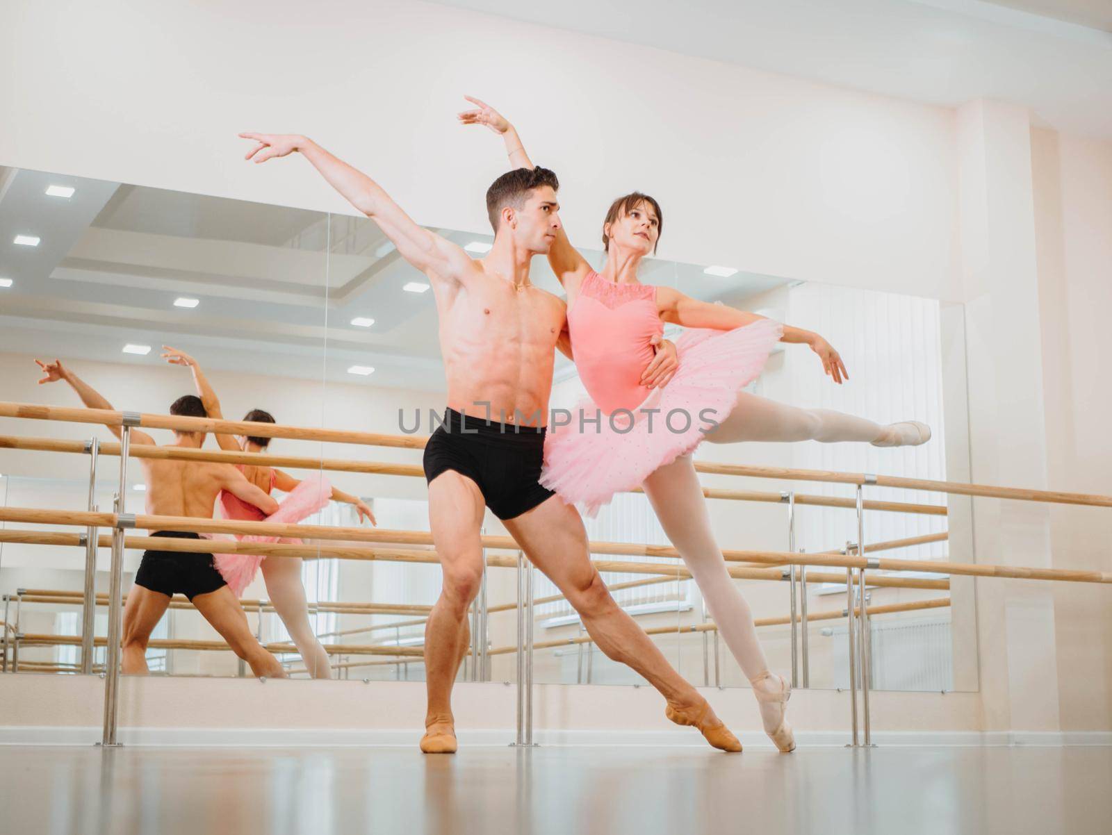 Professional, emotional ballet dancers practicing in the gym or hall with minimalism interior. Couple dancing a sensual dance before performance. by kristina_kokhanova