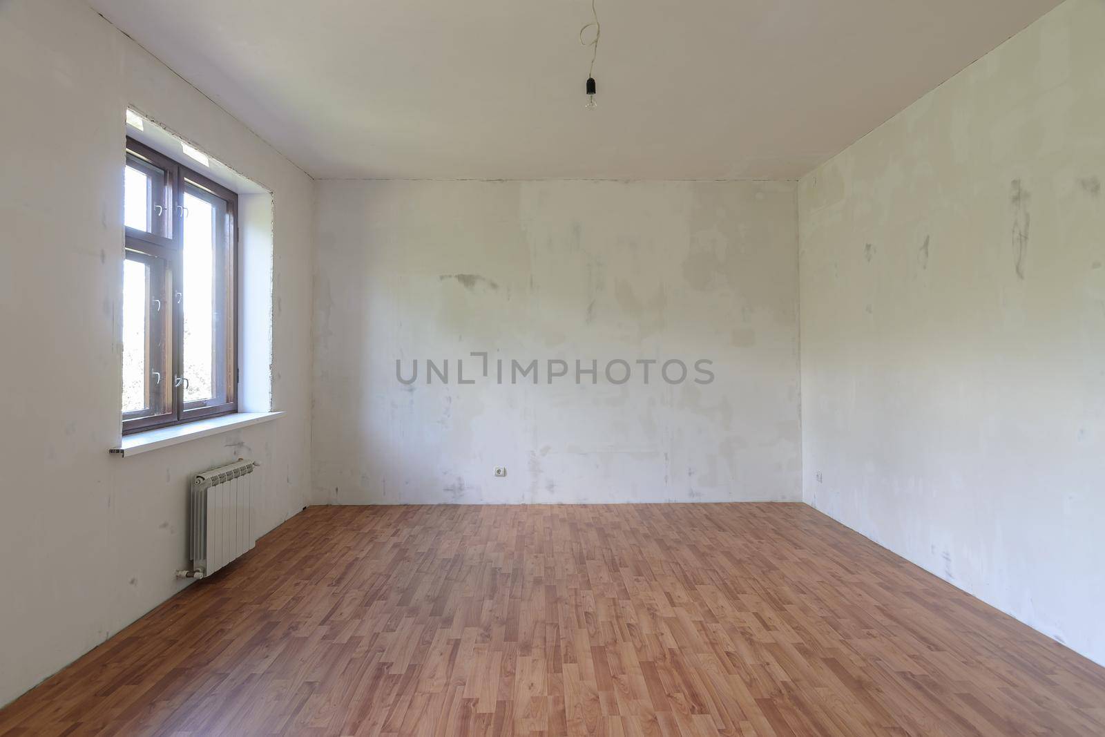 Interior of a small empty room with one window during renovation a