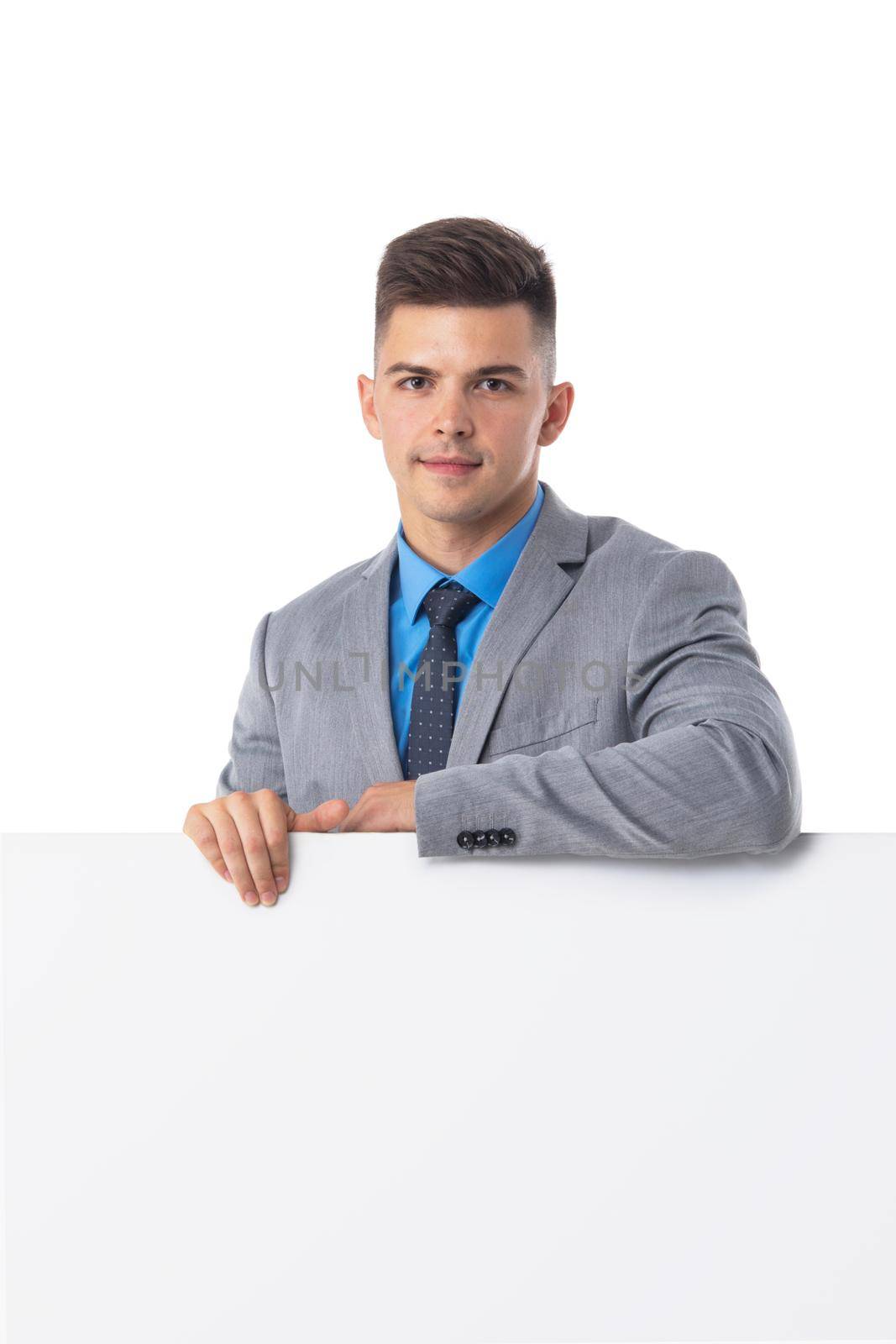 Young man in suit showing banner whiteboard sign isolated on white background