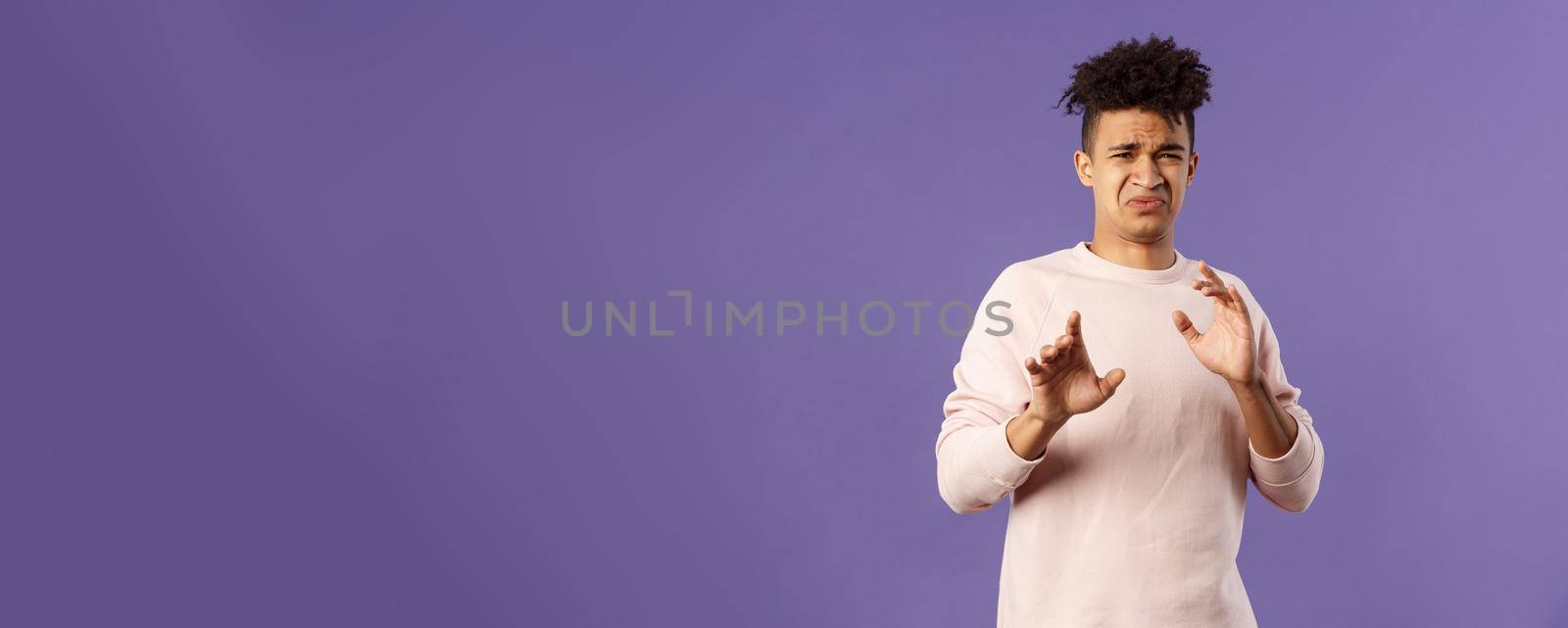 Phew get it away from me. Portrait of disgusted young man smelling something awful, step away and blocking it with raised arms, refuse grimacing with aversion and reluctance, purple background by Benzoix