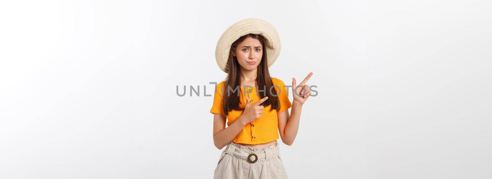 young pretty woman looking unhappy and stressed, suicide gesture making gun sign with hand, pointing to copy space