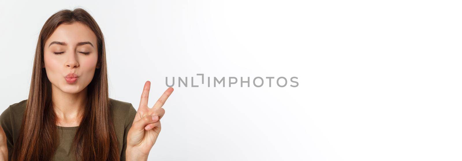 Young woman showing two fingers, positive or peace gesture, on white. by Benzoix