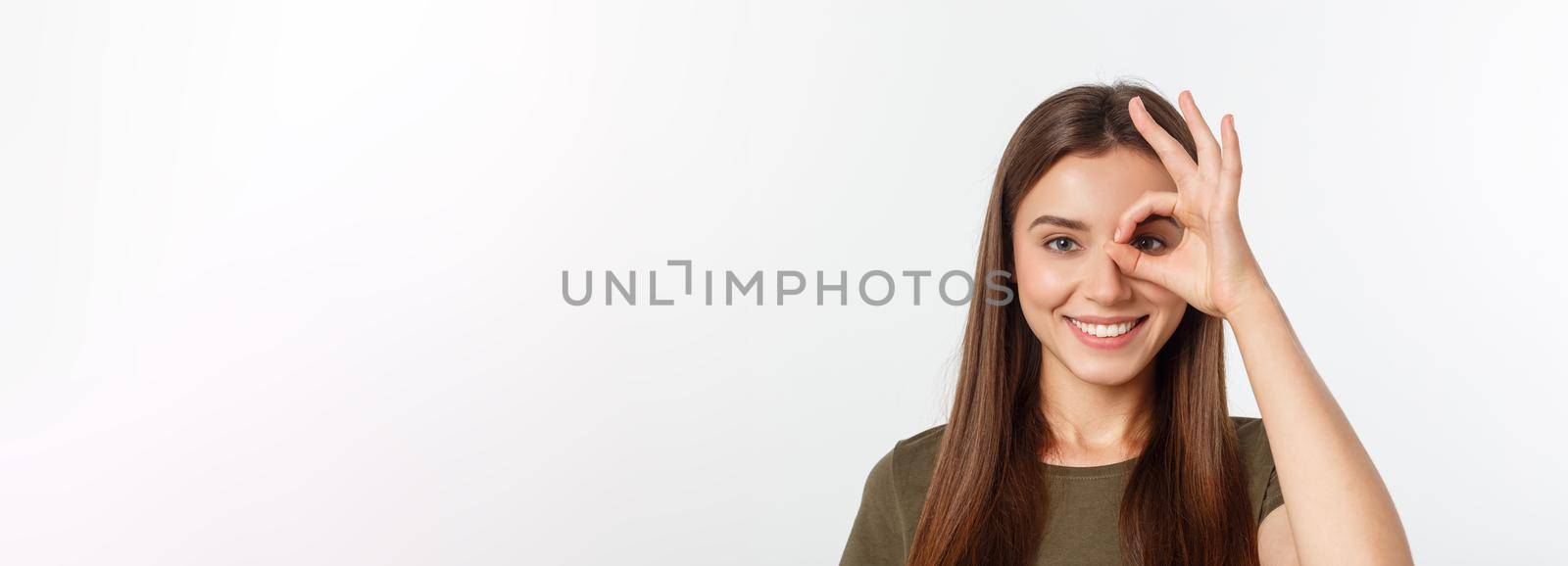 Young woman with ok sign on eye isolate over grey background. by Benzoix