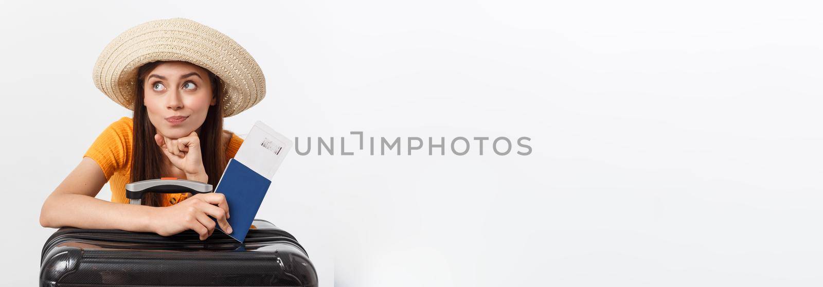 Travel concept. Studio portrait of pretty young woman holding passport and luggage. Isolated on white.