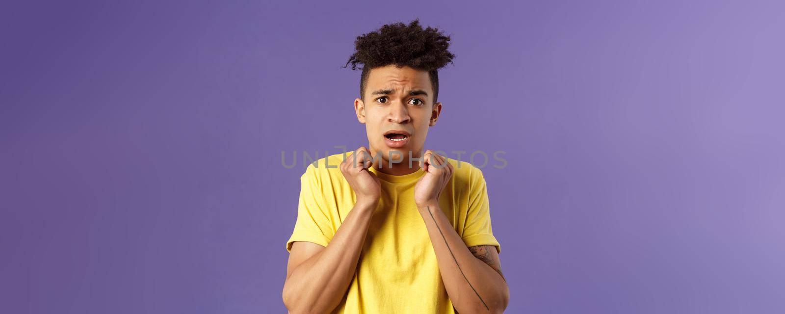 Close-up portrait of timid, insecure and worried young hispanic guy worried for own safety being in house alone, hear scary noises from downstairs, trembling fear, look concerned and afraid.