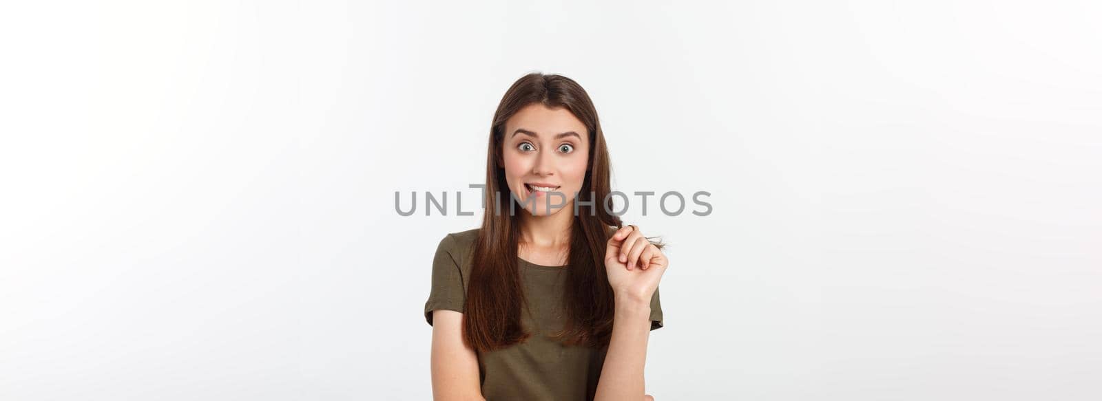 amazement - woman excited looking to the side. Surprised happy young woman looking sideways in excitement. Mixed race Asian and white Caucasian female model on grey background. by Benzoix