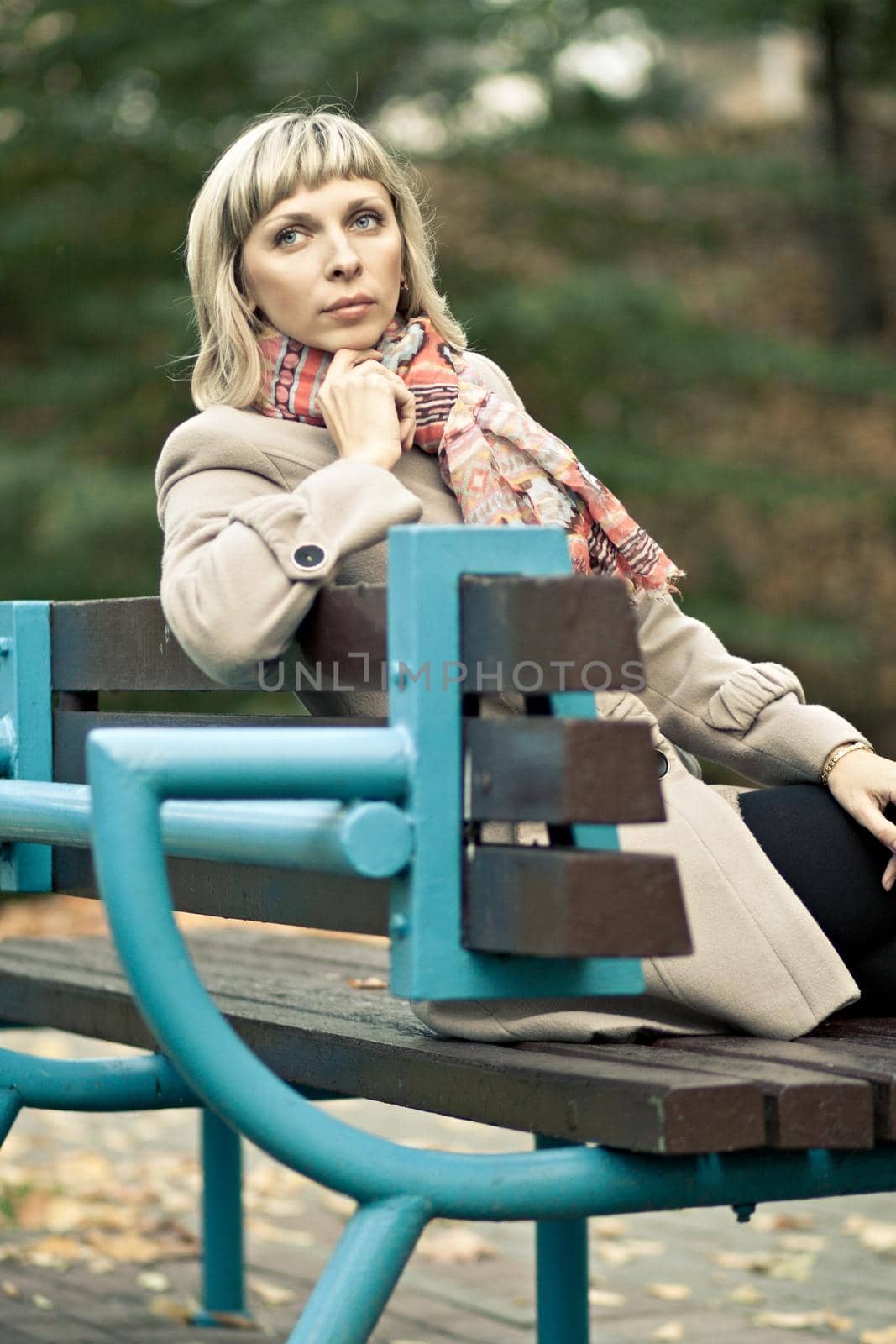 portrait of a beautiful woman sitting on a bench in the park
