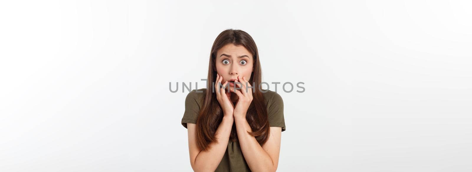 Close-up portrait of surprised beautiful girl holding her head in amazement and open-mouthed. Over white background by Benzoix