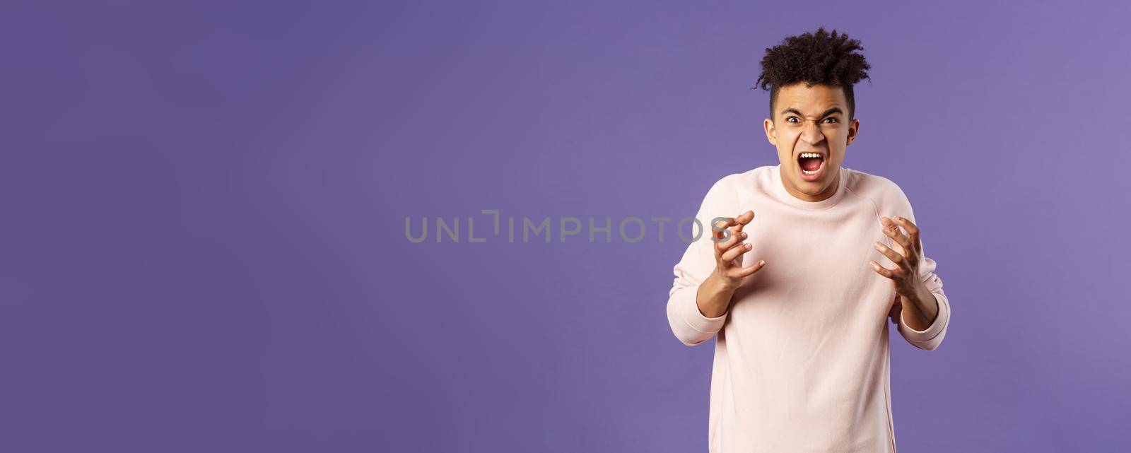 Portrait of hateful, outraged young hispanic man losing his temper, want to strangle or attack someone, cursing being aggressive, squeeze hands into fist from rage and hate, purple background by Benzoix