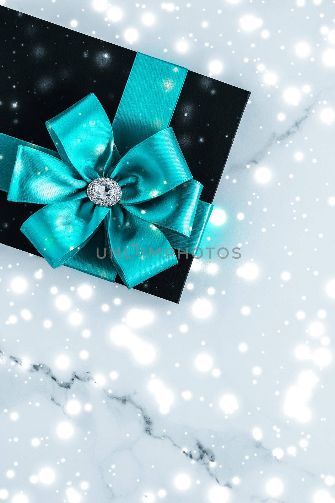 New Years Eve celebration, wrapped luxury boxes and cold season concept - Winter holiday gifts with emerald silk bow and glowing snow on frozen marble background, Christmas presents surprise