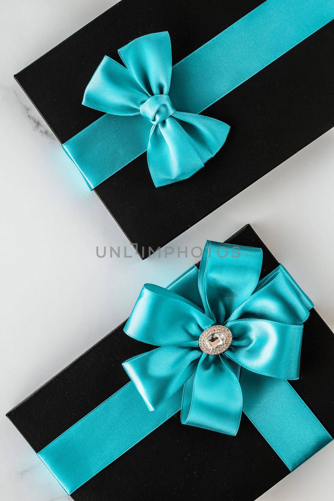 Luxury holiday gifts with emerald silk ribbon and bow on marble background by Anneleven