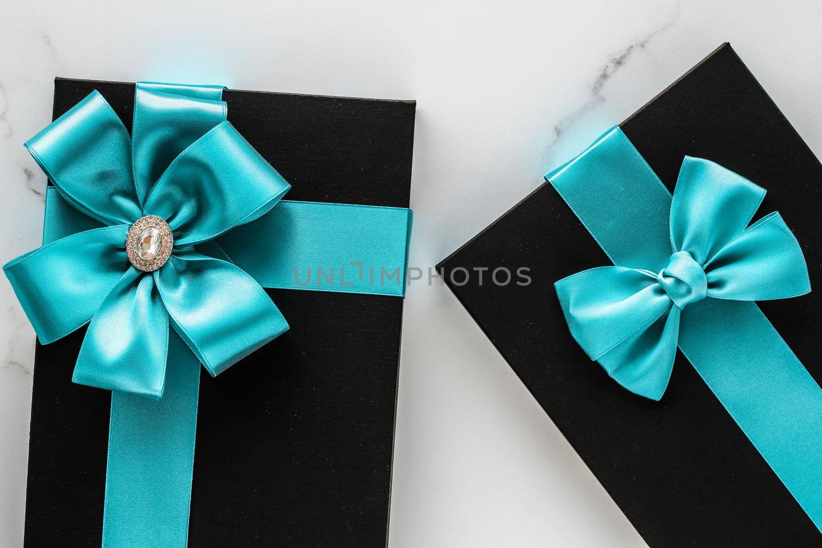Luxury holiday gifts with emerald silk ribbon and bow on marble background by Anneleven