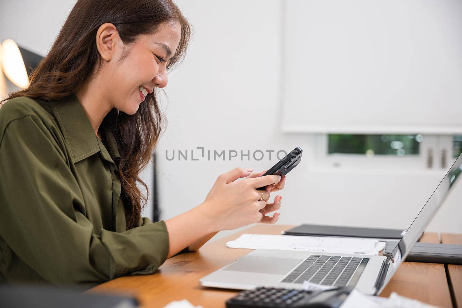 Asian young woman pay for goods digital payment success on smartphone, Smile female buy product on laptop computer she pay money by mobile phone, Easy E-commerce shopping online, lifestyles technology