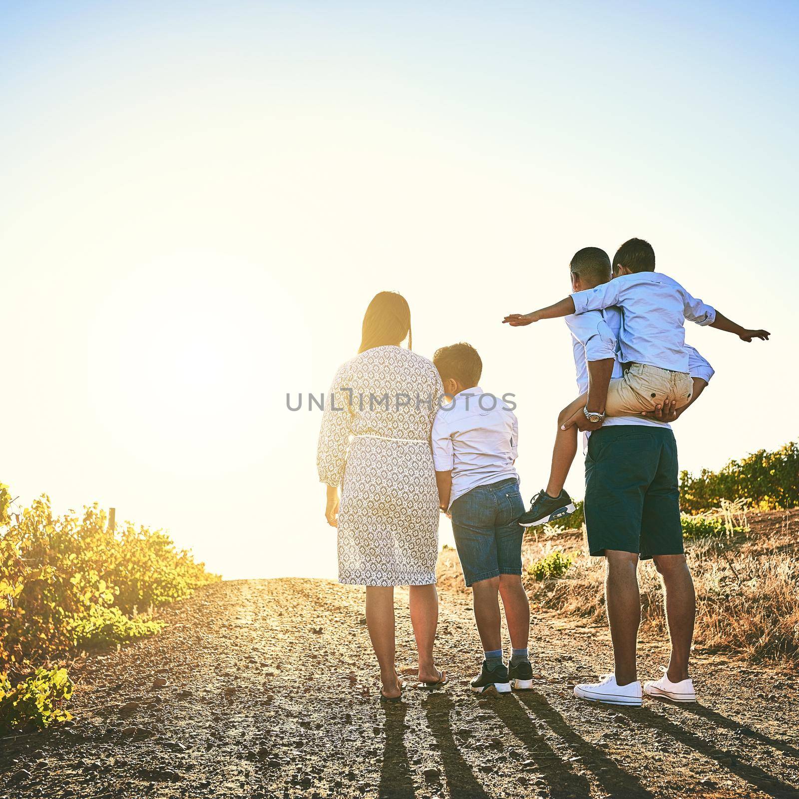 Nothing says love like quality time. Rearview shot of a family bonding together outdoors. by YuriArcurs