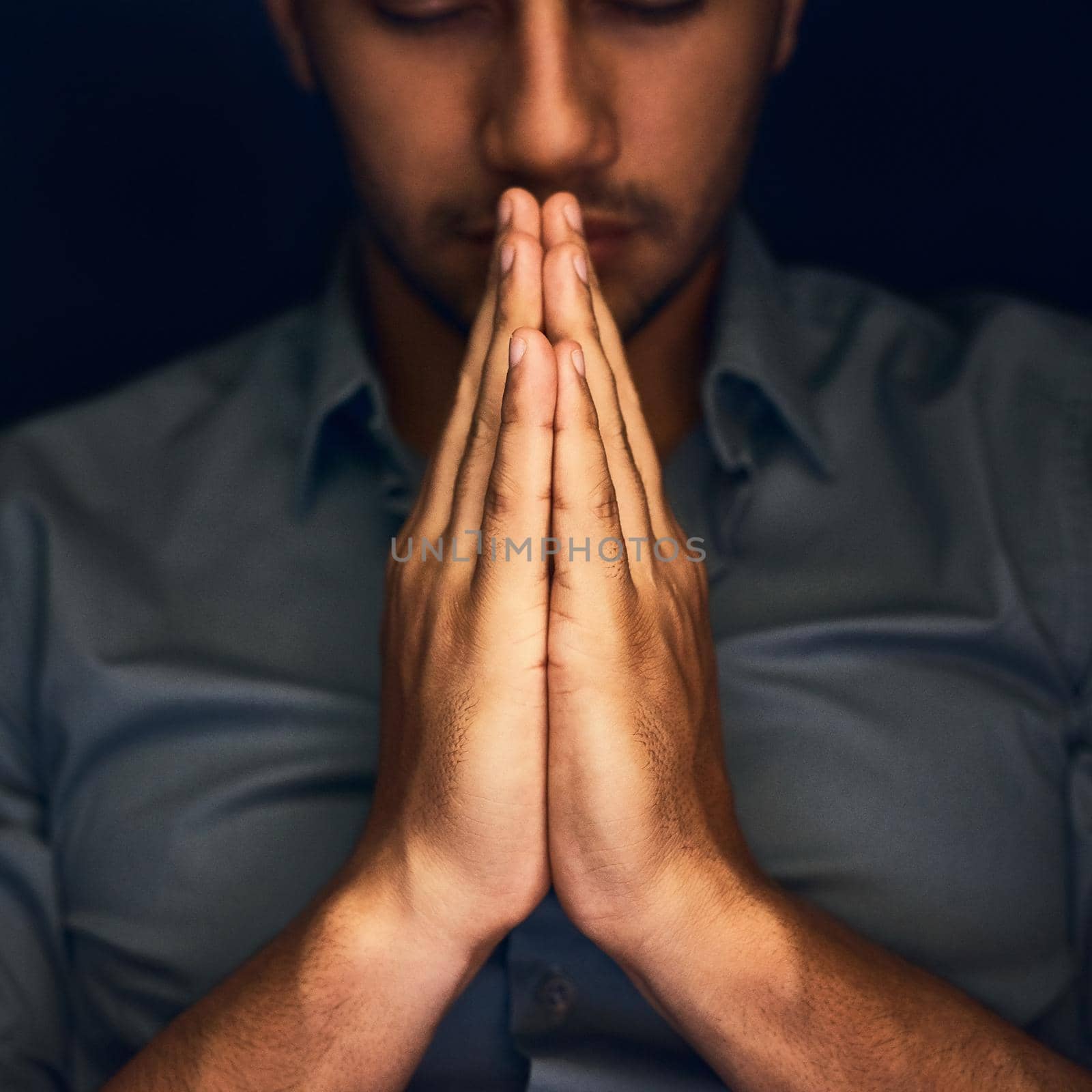 Give us this day our daily bread. Closeup shot of a young man praying with his eyes closed